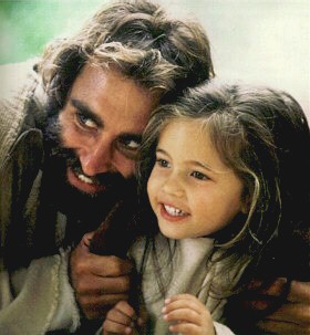 A touchable, very real Jesus laughs with a little girl. (Bruce Marchiano in "Matthew")