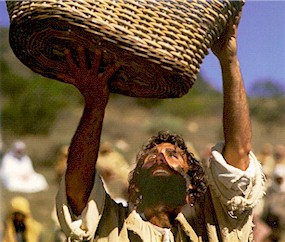 Jesus hoists a basket of loaves and fish heavenward as He thanks His Father before feeding the 5,000.  (Bruce Marchiano in "Matthew")